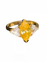 Front angled view of ring showing yellow marquise stone and clear triangular side stones
