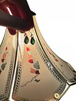 Earrings back-lit against lamp shade showing color and translucency