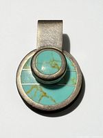 Front view of round sterling silver pendant with turquoise inlay