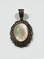 Front view of pendant showing cabochon and filigree border