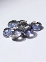 Six faceted tanzanite stones grouped on white background
