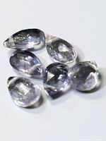 Six pear-cut tanzanite gemstones displayed on white background showing overall shape and color