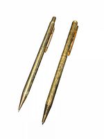 Two gold-tone pens side by side showing overall form and finishes