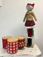 Three red Christmas canisters with bamboo lids and standing plush fox