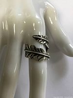 Ring on mannequin hand showing leaf wrap design