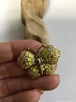 Front view of brooch showing enamel, gemstones, and signature style