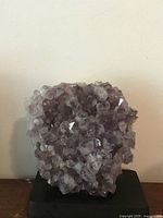 Front view of amethyst geode cluster on stand