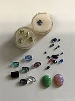 Overall view of loose gemstones and two gem jars