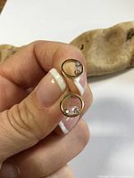 Front view showing both gold circle earrings and diamond chips