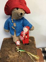 Group shot of Paddington Bear plush, two Santa ornaments, and glass bird ornament