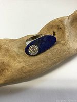 Ring front showing lapis lazuli oval face and round crystal accent