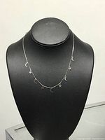 Full view of sterling silver necklace with moon and star charms on bust form