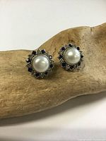 Front view of both stud earrings showing pearls and gemstone settings