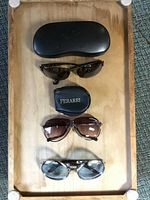 Tray with Ray-Ban case, Ray-Ban sunglasses, Ferrari case, Ferrari sunglasses, and unbranded aviators