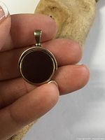 Carnelian side of spinner pendant held in hand