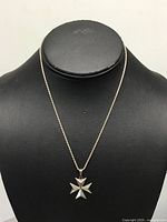 Full view of necklace on display bust showing rope chain and cross pendant