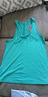 Front view of turquoise Eddie Bauer racerback tank top laid flat