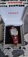 Guess wristwatch with red strap in branded box