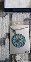 Necklace on Guess card showing pendant and chain, price tag visible
