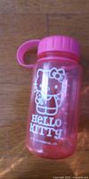 Front view of pink Hello Kitty water bottle showing graphic and lid
