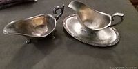 Both silver gravy boats side by side