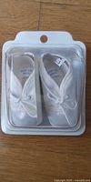 Front view of packaged white infant shoes size 1