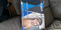 Sealed retail box of Iriber shower system on couch