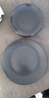 Top view of one dinner plate and one medium plate displaying matte black finish