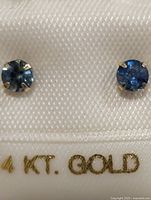Front view of sapphire studs on card showing stones and gold prongs