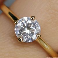Close-up of moissanite stone in prong setting on gold band