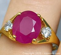 Ring on finger showing ruby and accent stones