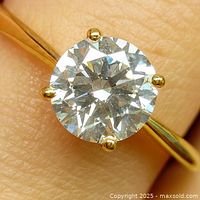 Ring on finger showing gold band and diamond