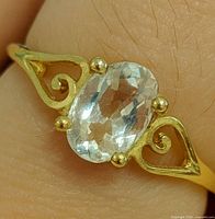 Close-up view of ring on finger showing overall design and gemstone