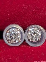 Front view of both round diamond studs in red box