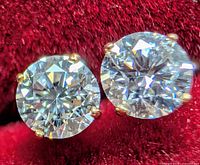 Close-up of both stud earrings showing round brilliant lab diamonds in four-prong gold settings