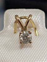 Front view of 14K yellow gold pendant showing round diamond in four-prong setting