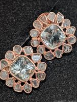 front view of both earrings showing blue topaz centers and diamond halos