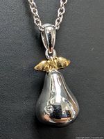 Close-up of pendant front showing gold-tone leaf and stone detail