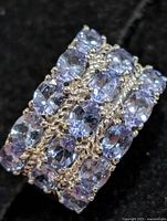Front view of ring showing four rows of oval tanzanite stones