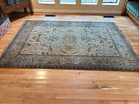 Full view of wool Oriental area rug laid on hardwood floor