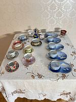 All teacups, saucers, sugar pot and vase arranged on table