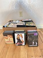 Box filled with DVDs plus three individual cases displayed