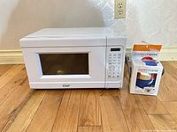 Front view of microwave and boxed cleaner