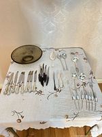 Overview of flatware and glass bowl laid out on table