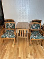 Front view of oak table flanked by four upholstered chairs