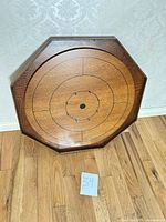 front view of octagonal wooden crokinole board showing full playing surface