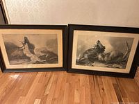 Both framed lithographs side by side on floor