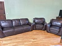 Sofa with two matching armchairs set on hardwood floor
