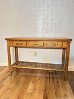 Front view of solid oak console table with drawers closed and slatted shelf visible