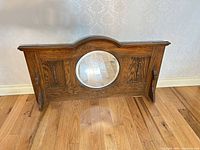 Front view of solid oak mantle piece with round mirror and side supports